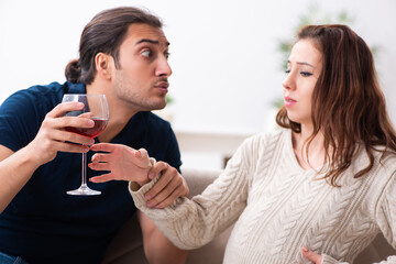 Man and pregnant woman in alcoholism concept