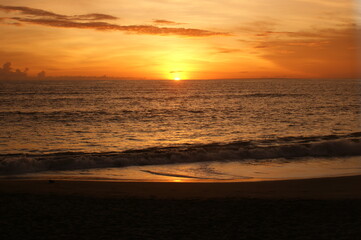 Sunset over Coast with sand and waves in orange color
