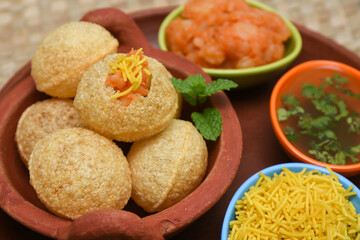 Spicy Pani puri golgappe and  potato stuffing, Chat item, India. panipuri, North Indian street food snack served with tangy tamarind water, chaat masala, chickpeas Delhi, Mumbai, Rajasthan, Bangalore
