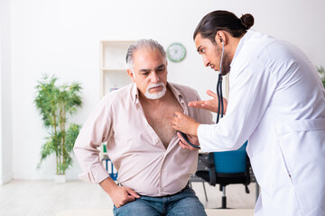Obraz premium Old man visiting young male doctor cardiologist