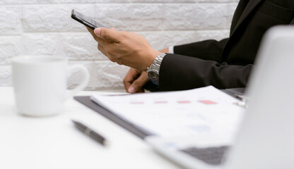 Business men hold smartphones to check information at the office