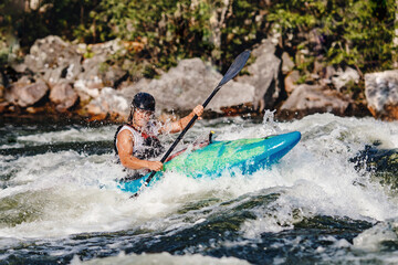 Extreme sport rafting whitewater kayaking. Guy in kayak sails mountain river