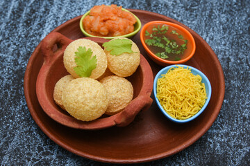 Spicy Pani puri golgappe and  potato stuffing, Chat item, India. panipuri, North Indian street food snack served with tangy tamarind water, chaat masala, chickpeas Delhi, Mumbai, Rajasthan, Bangalore