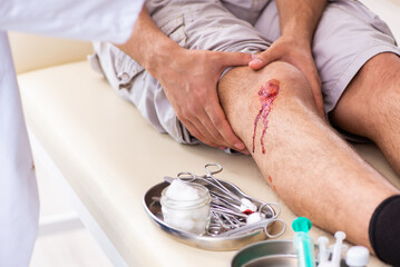 Leg injured man visiting old doctor in first aid concept