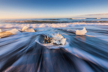 Summer scene in the morning and powerful of white streams and big iceberg at Black Beach with blue sky ,Iceland