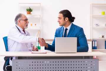 Fototapeta premium Young businessman meeting with old doctor