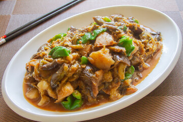 Eggplant and potato stew in a white plate close up. Chinese food
