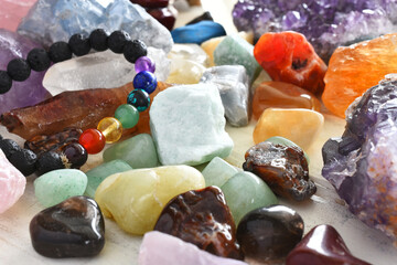 A close up image of a healing chakra bracelet with other healing crystals. 
