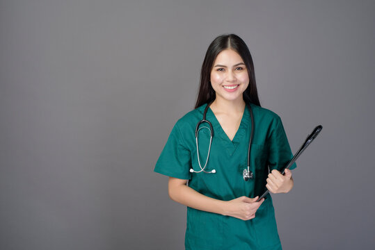 Young Happy Beautiful Woman Doctor Wearing A Green Scrubs Is Holding Documents