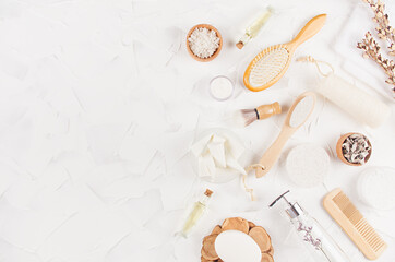 Fototapeta na wymiar Elegant beige natural cosmetic products and accessories with twigs for body and skin care on soft light white background, top view, copy space.