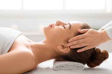 Beautiful woman having head massage at spa, closeup