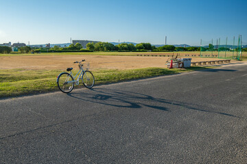 bicycle on the road alongside a small baseball field