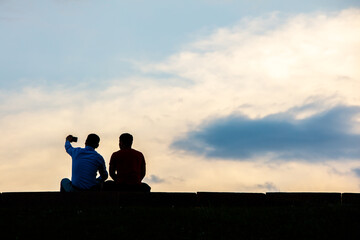 Two men take a selfie against the sky