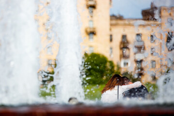 Fototapeta premium Couple relaxing near the fountain on a summer day