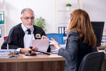 Old male judge and female client in the office