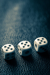 Dice with fives on a dark blue leather table.