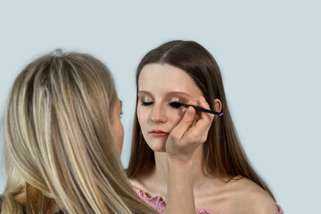 Professional beauty salon. A girl make-up artist makes a makeover client.