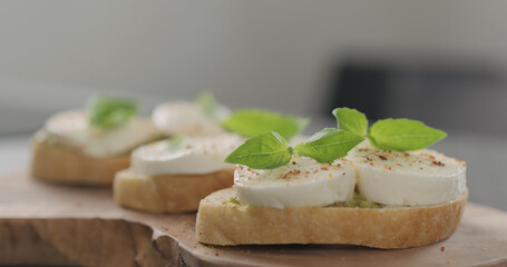 bruschetta with pesto and mozzarella on olive board