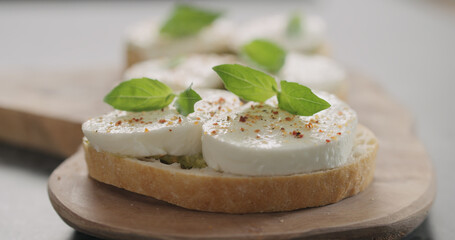 bruschetta with pesto and mozzarella on olive board