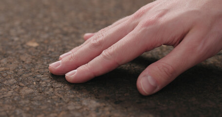 man hand touch dark cork surface with oil finish
