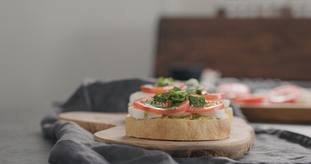 bruschetta with tomato, pesto and mozzarella on olive board