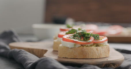 bruschetta with tomato, pesto and mozzarella on olive board