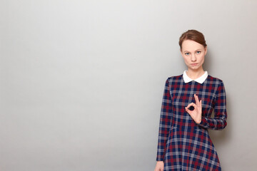 Portrait of serious girl showing okay gesture or zero with fingers