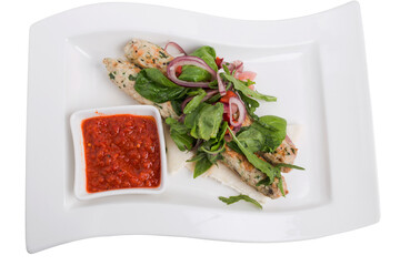 Chicken kebab with spicy tomato sauce on skewers.
