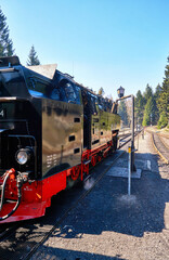 Detail of an antique red black steam locomotive at the train station.