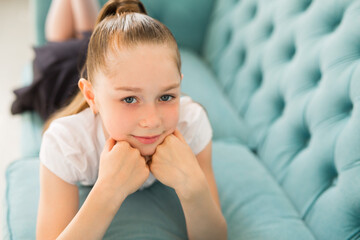 beautiful young girl teenager lies on a sofa
