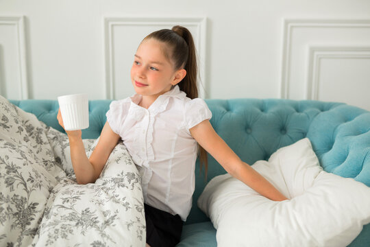 beautiful young teenager girl in a blanket with a mug