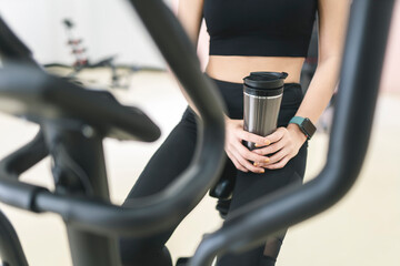 Fitness woman exercise in the gym and drinking water from bottle.