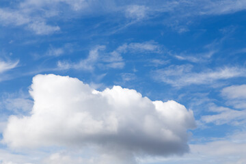 Naklejka na ściany i meble Lonely large cloud in the blue cloudy sky.