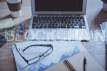 Double exposure of blockchain and crypto economy theme hologram and table with computer background....