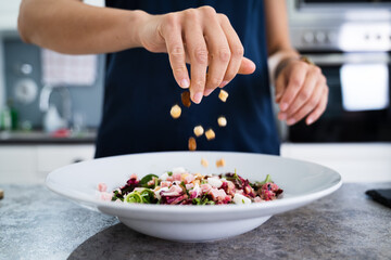 Obraz na płótnie Canvas Woman Cooking Salad In Kitchen