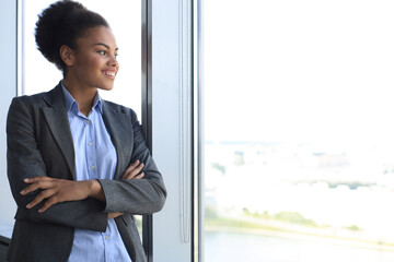 Attractive african american business woman smiling while standing in the office.