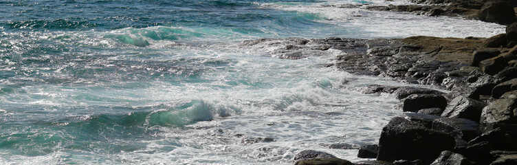 Beautiful view of rough rocks and coast and blue frothy sea