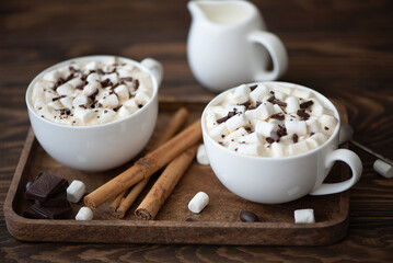 two cups of black coffee with chocolate and marshmallows