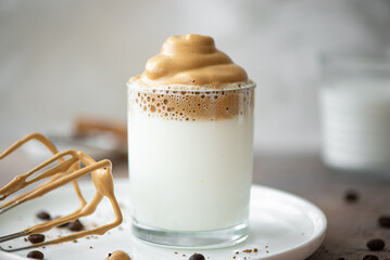Dalgona coffee with coffee beans in a glass glass