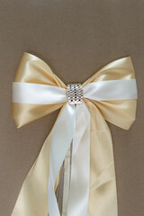 beautiful golden wedding bow on brown background