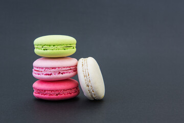 Colorful macarons on black background.