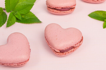 heart shaped macaroons in pink with cream and fresh mint