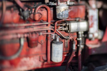 Selective focus closeup shot of a red rusted fuel system of a tractor