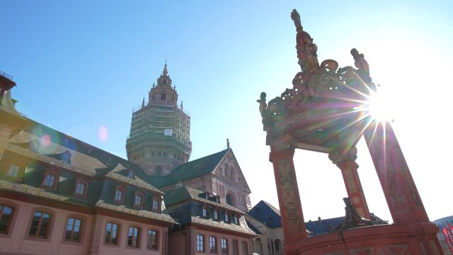 The Mainzer Dom, Mainzer cathedral, Hohe Dom St. Martin Mainz and the Marktbrunnen market fountain in the foreground on a sunny day with blue sky and lens flare wide angle shot