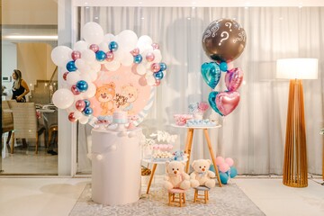 Table with cake sweets and balloons for a gender revealing party