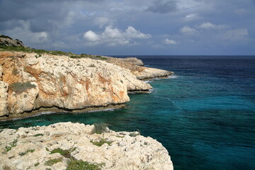the rocky coast of the island with swirling clouds in the sky