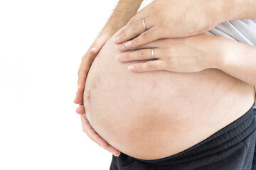 出産予定日の近い妊婦と夫がお腹を触る