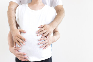 出産予定日の近い妊婦と夫がお腹を触る