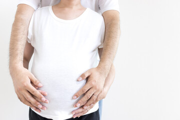 出産予定日の近い妊婦と夫がお腹を触る