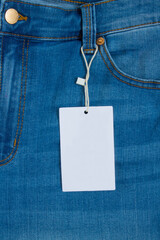 Blue classic jeans close up and a white rectangular empty label with space to copy
